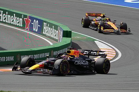 Dutch Grand Prix 2024: Red Bull driver Max Verstappen of the Netherlands, left, steers his car followed by McLaren driver Lando Norris of Britain
